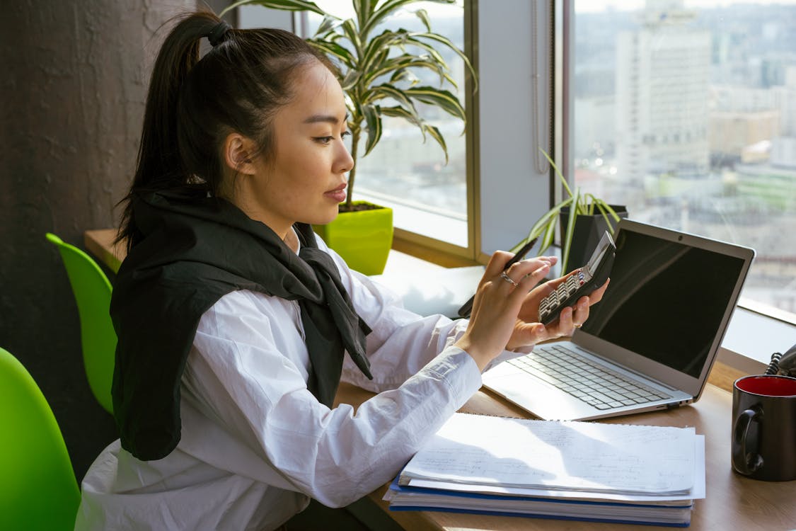 Free A Woman Computing with a Calculator Stock Photo