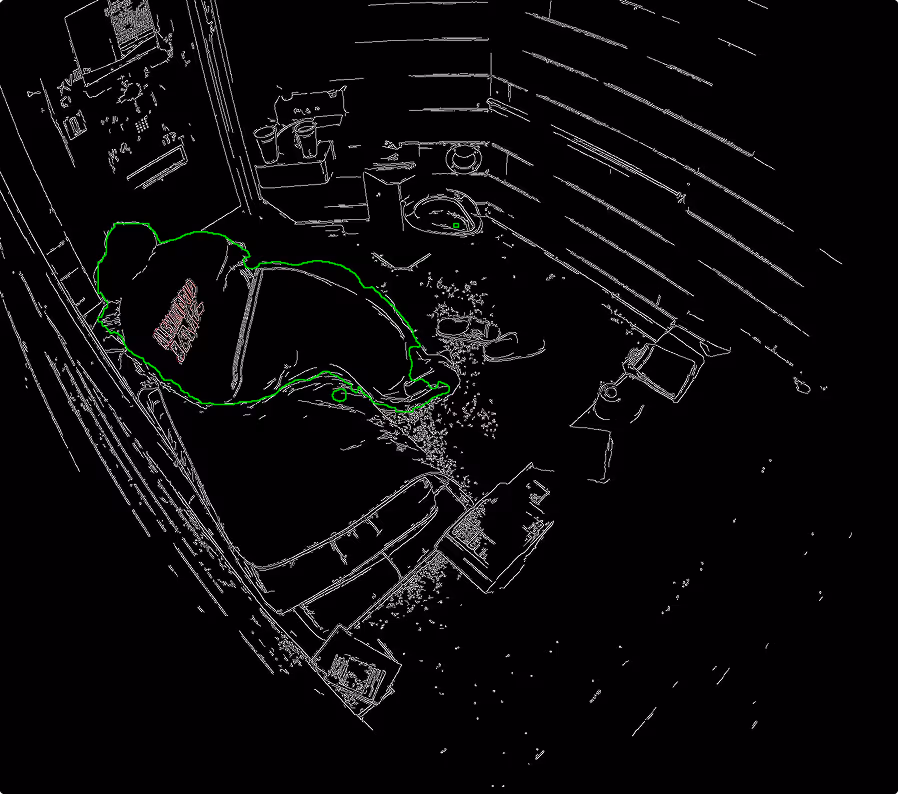 Person in a hoodie crouching inside a small, cluttered room.