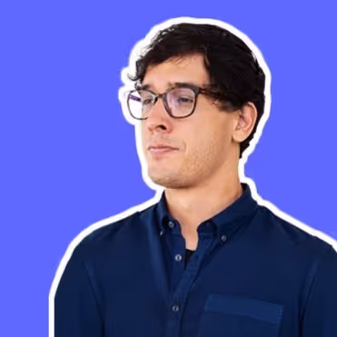 Jonge man met donkere krullende haren en bril, gekleed in een donkerblauw overhemd, kijkt naar links tegen een effen paarse achtergrond.