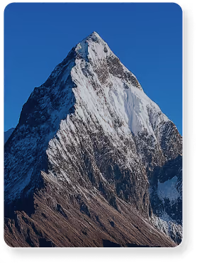 Pointe de montagne enneigée avec ciel bleu clair en arrière-plan.