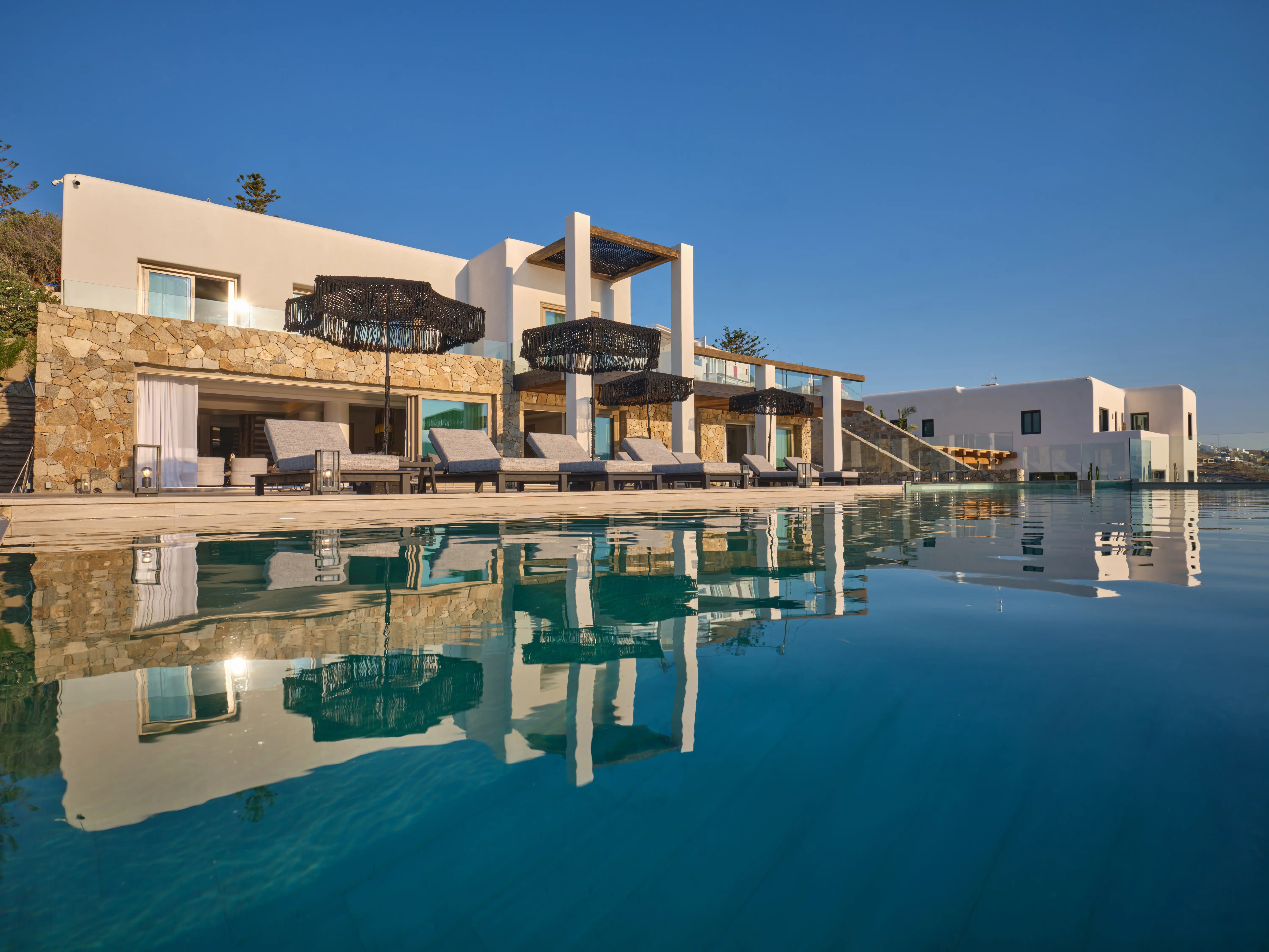 A pool infront of a villa.