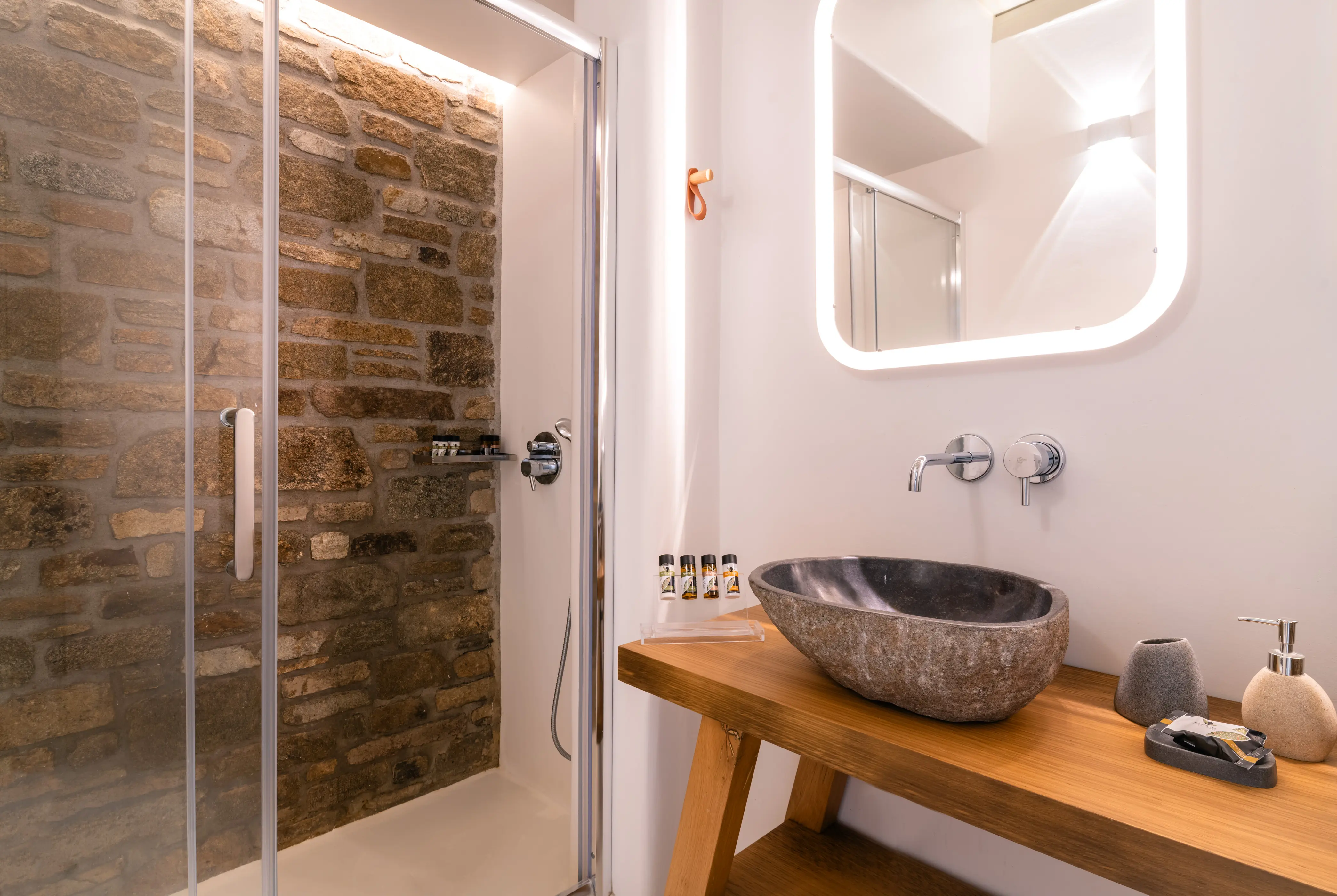 A stone sink on the right and a stone shower on the left.