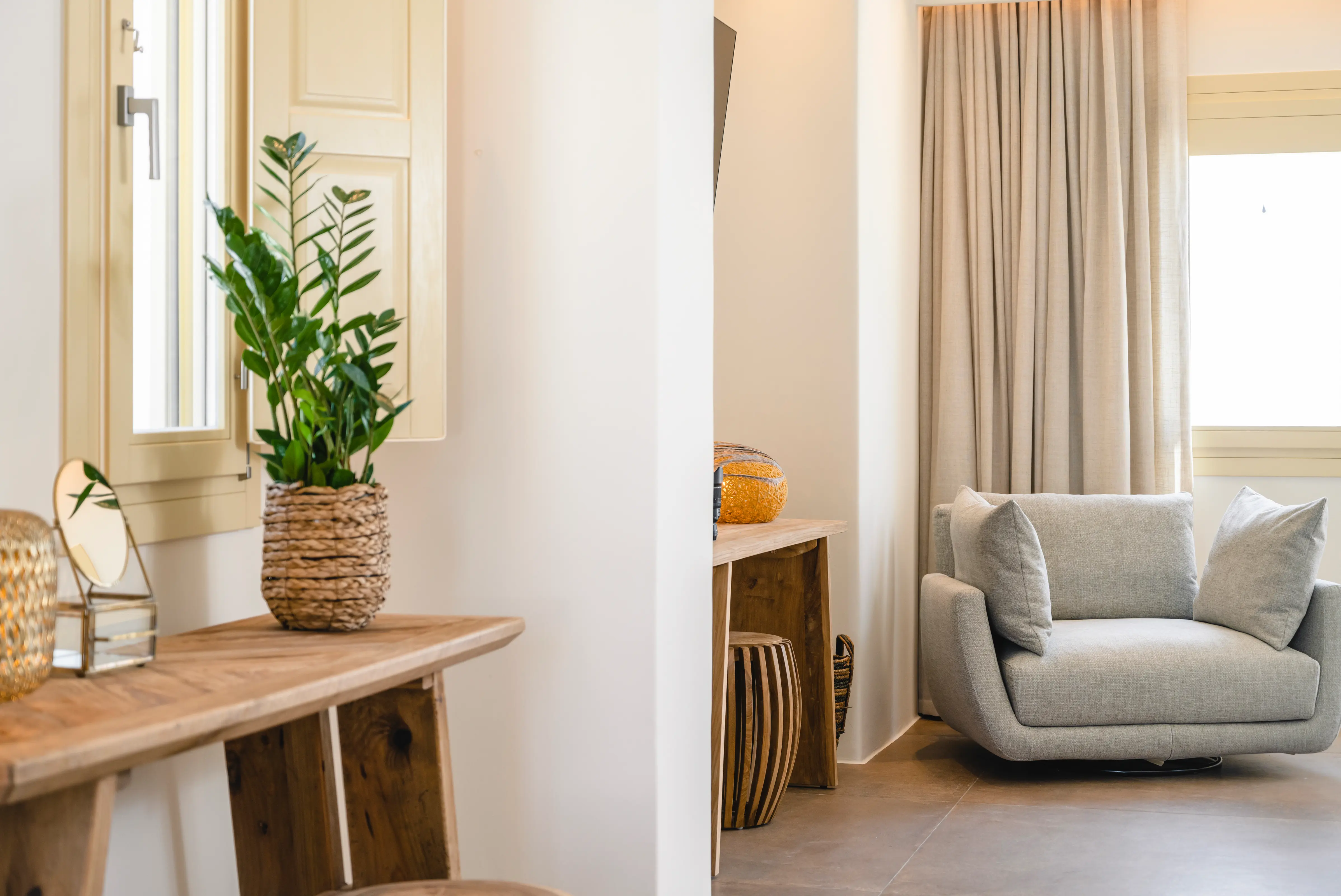 A wooden table on the left and a grey armchair on the right.