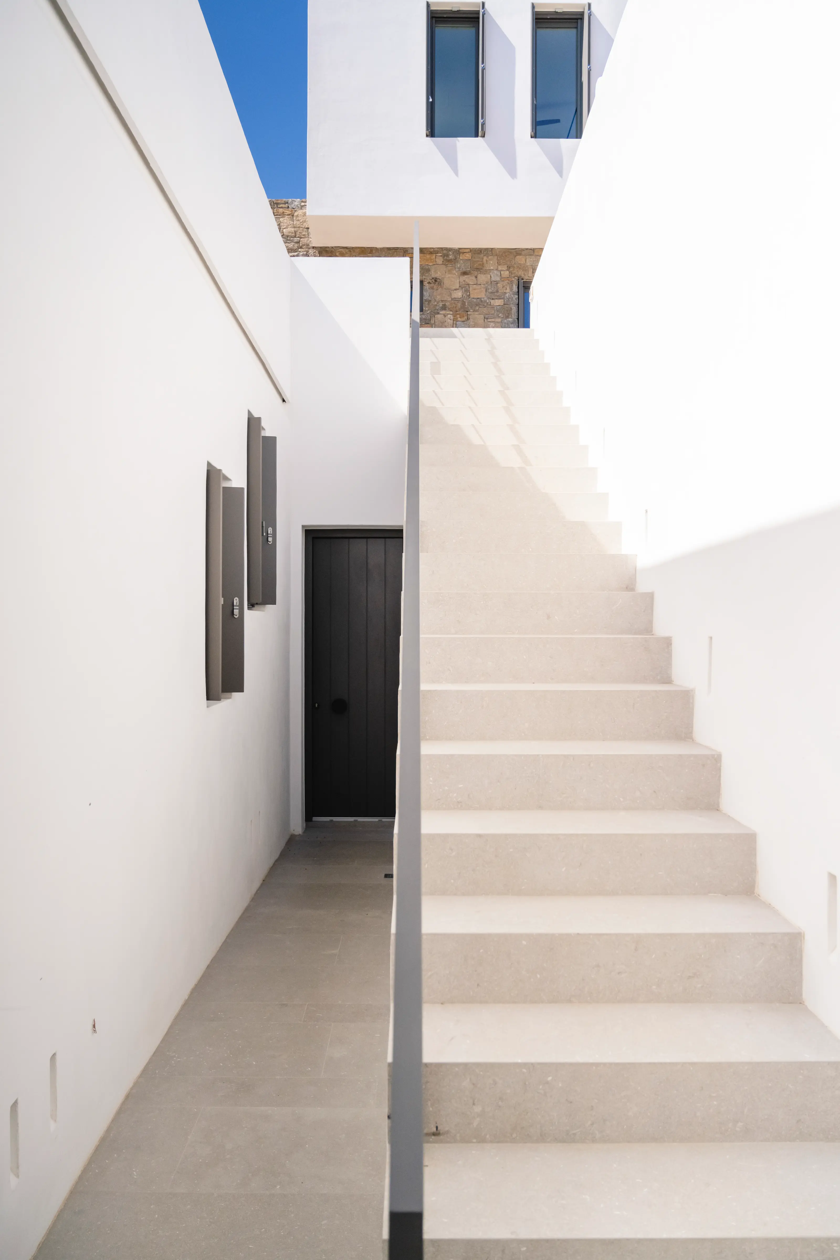 A black door and a white stairway.