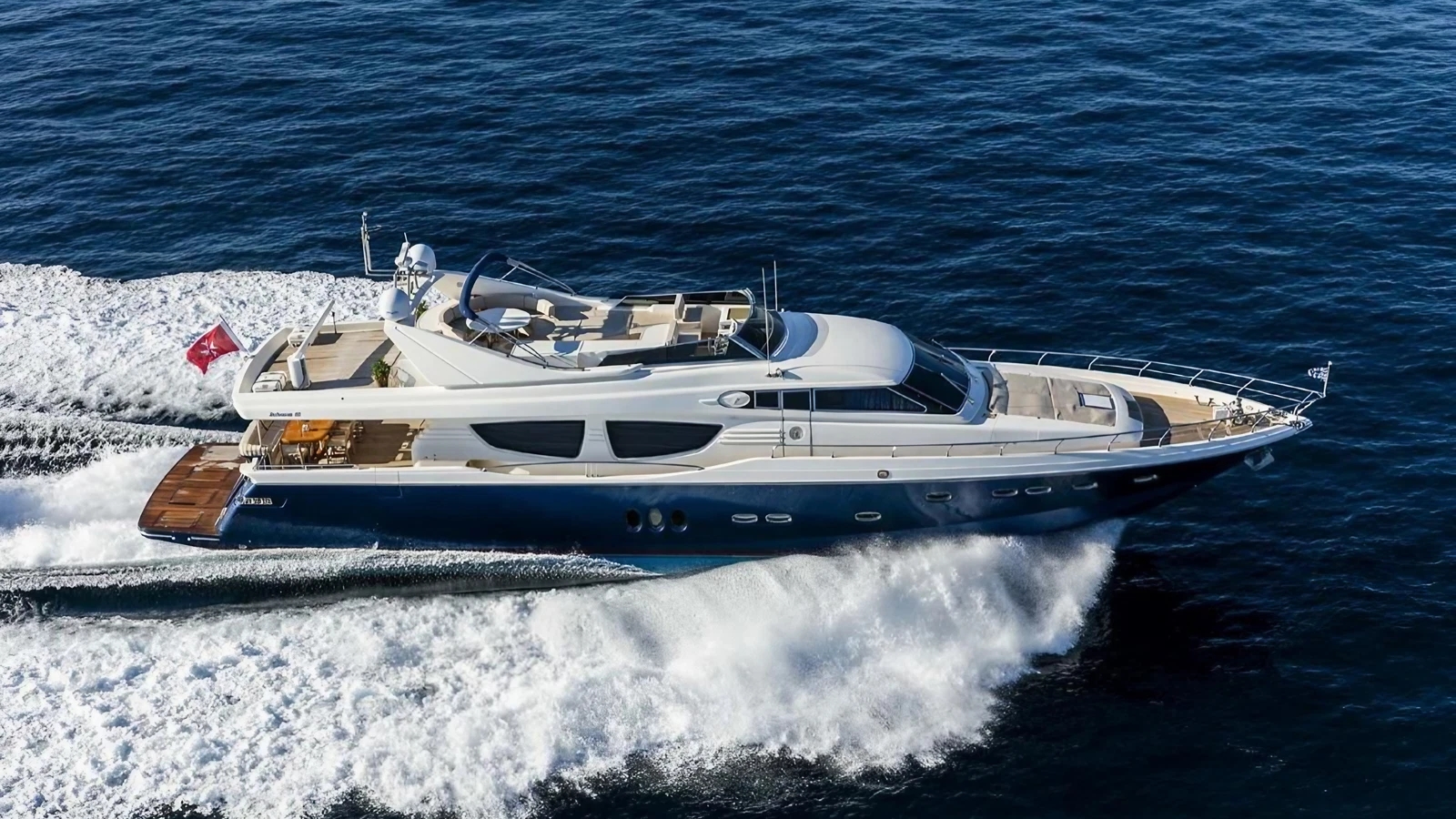 An aerial view of a blue and white yacht sailing.