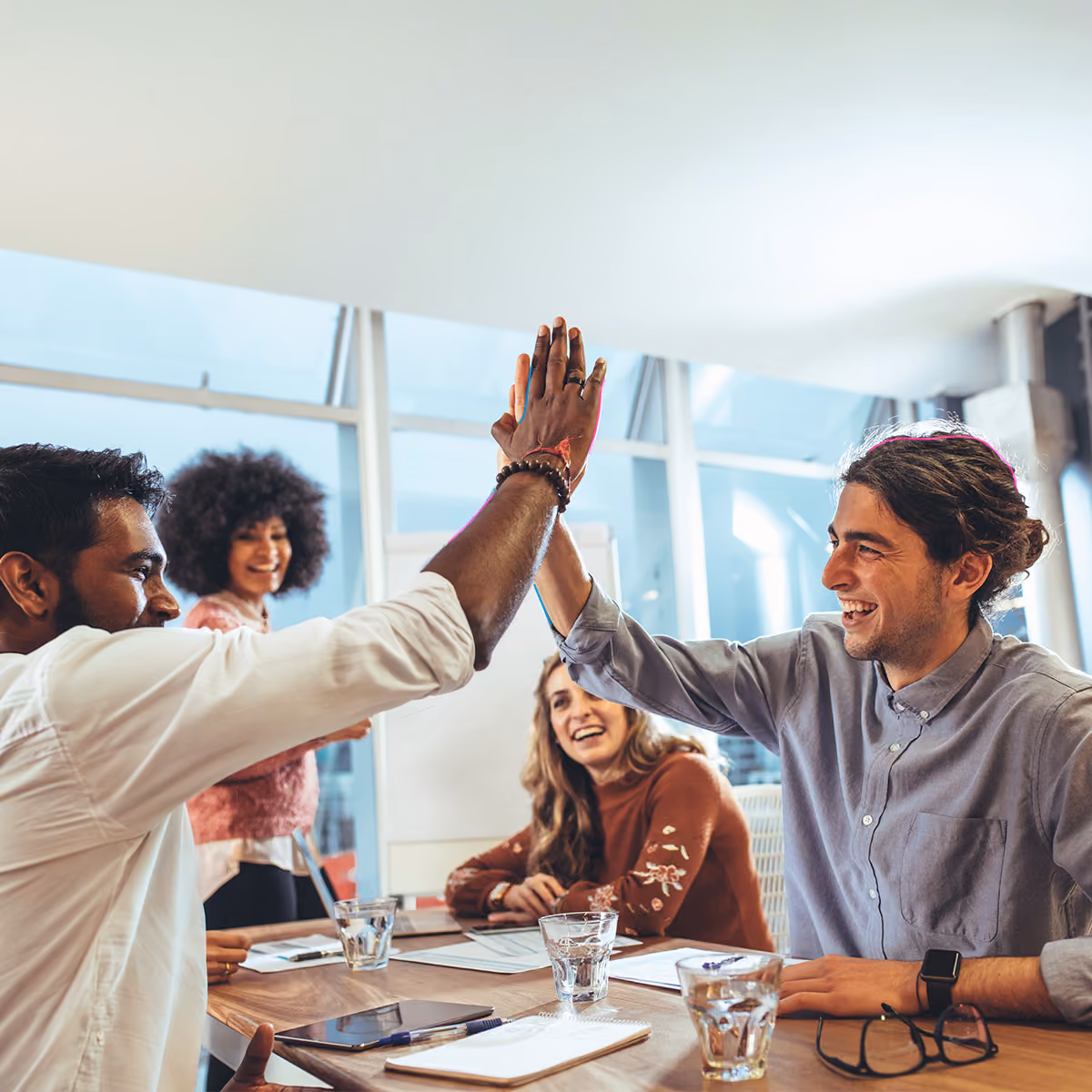 Employees celebrating and high-fiving in the office