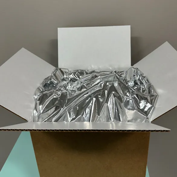 White paperboard insert opened inside a kraft corrugated shipping box.