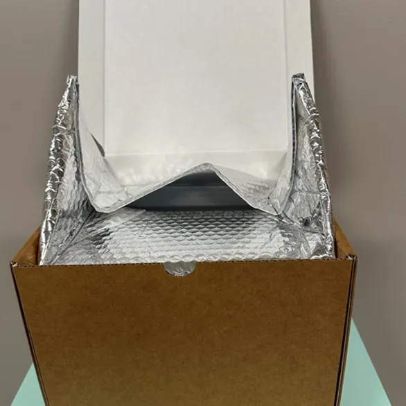 Advanced foil insulated liner folded around a product container inside a kraft corrugated shipping.