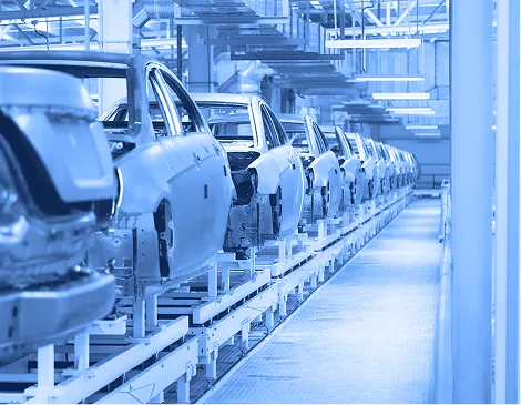 Automotive bodies aligned on an assembly line inside a manufacturing plant.