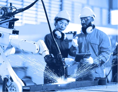 Workers operating industrial machinery in a manufacturing environment.