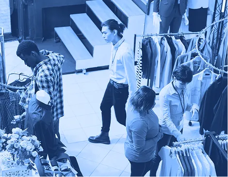 Shoppers browsing clothing racks inside a retail store.