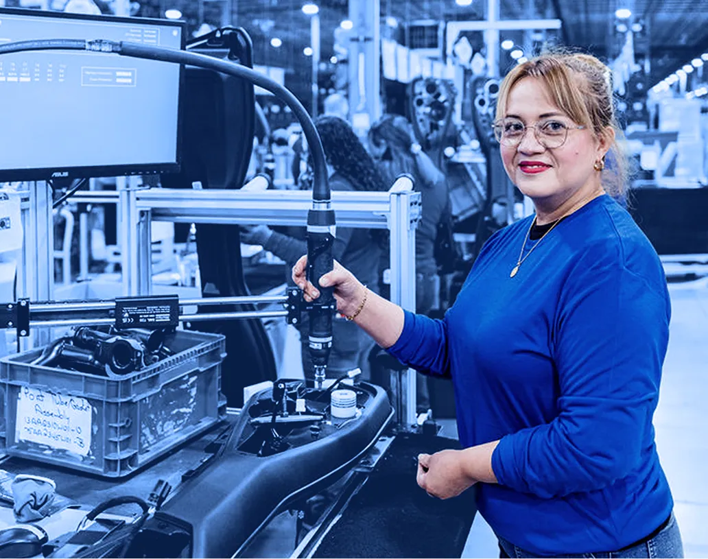 Assembly line operator working at an automated production station.