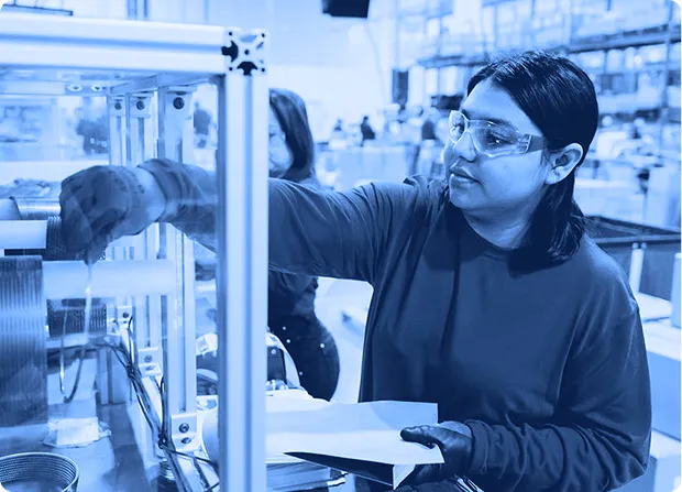 Assembly team member inspecting components at a workstation to verify quality and accuracy.