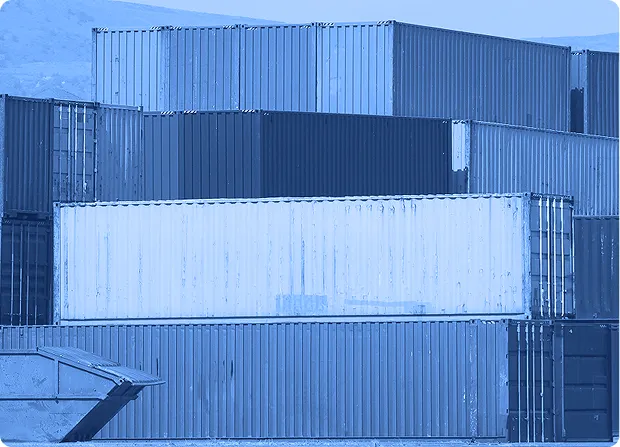 Stacked shipping containers arranged outdoors at a freight storage location.