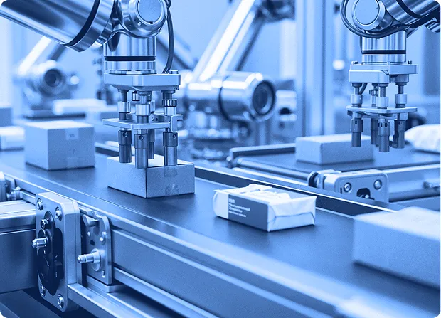 Automated packaging line placing small boxed items onto a conveyor system.