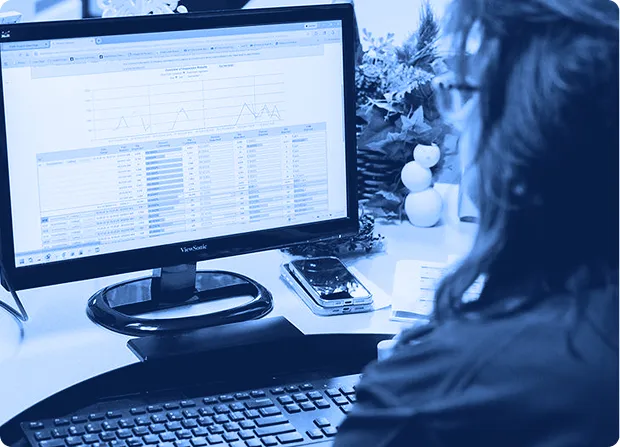 Employee reviewing inspection data on a computer monitor during a quality management process.