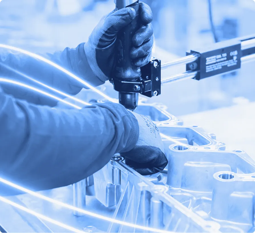 Technician fastening aluminum components on an assembly fixture during a production process.