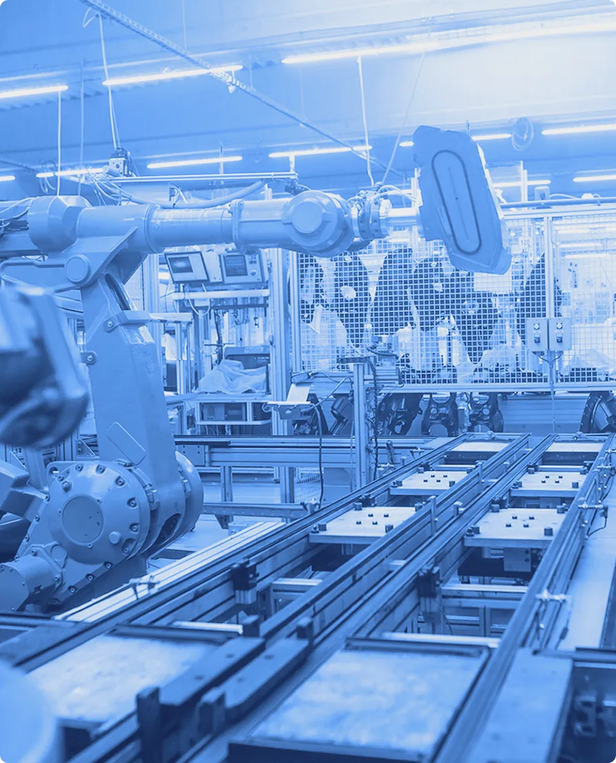 Robotic assembly equipment operating along a conveyor system inside a manufacturing facility.