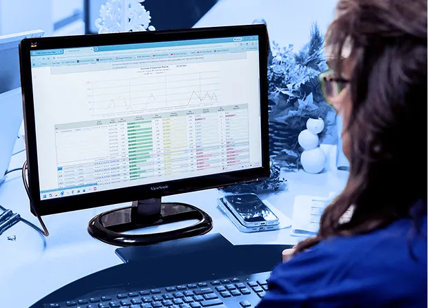 Employee reviewing inspection data on a computer monitor during a quality management process.