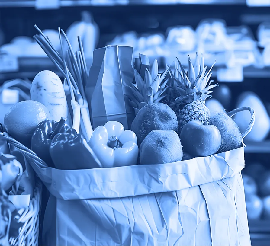 Paper grocery bags filled with produce displayed inside a retail grocery environment.  
