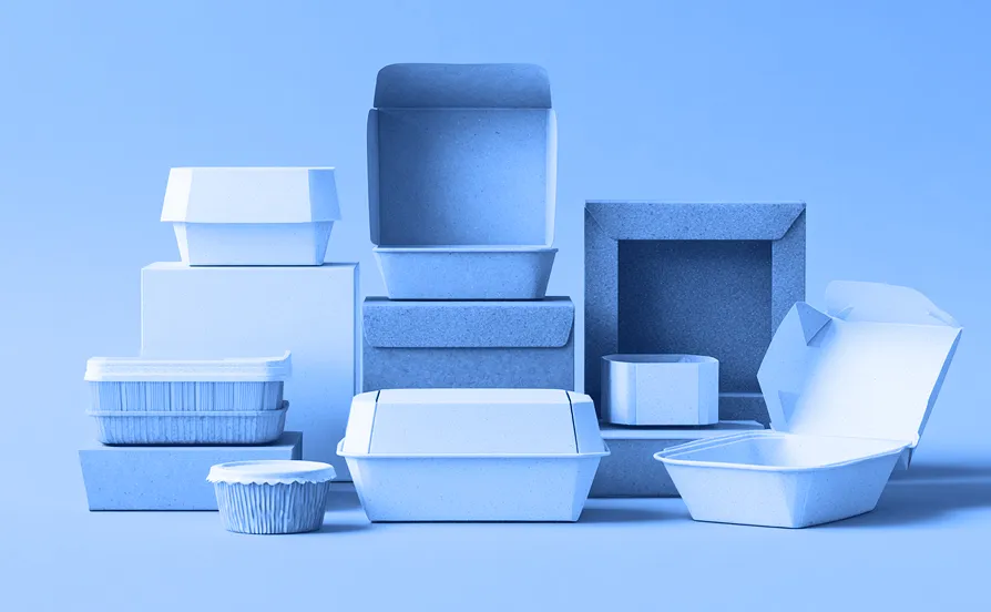 Assortment of molded fiber food containers and boxes in various sizes and colors arranged against a solid green background, including clamshells, bowls, and trays.