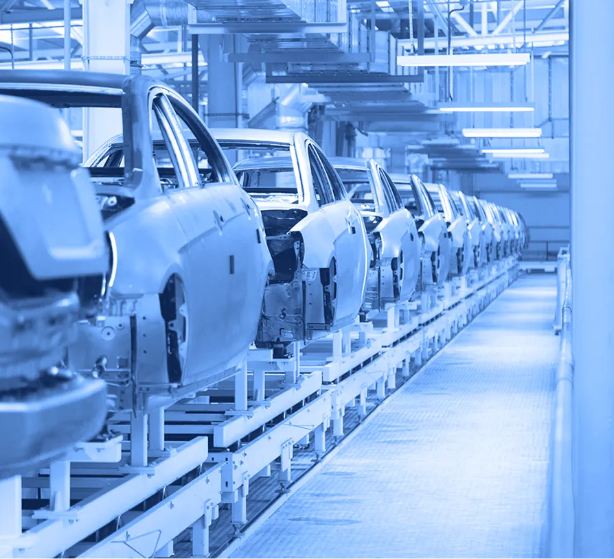 Automotive bodies aligned on an assembly line inside a manufacturing plant.
