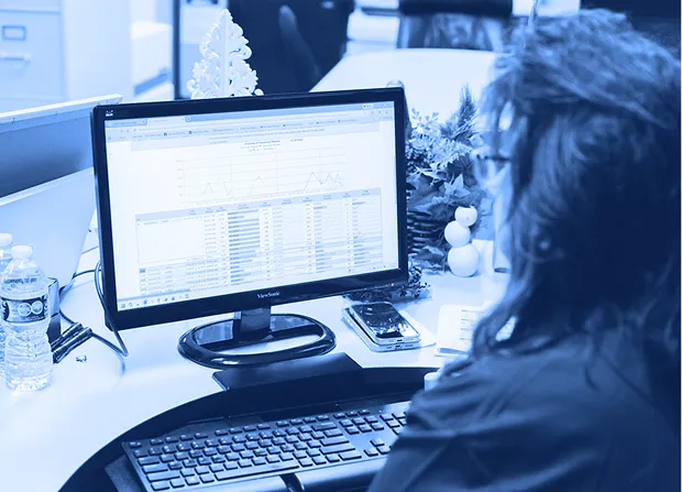 Employee reviewing inspection data on a computer monitor during a quality management process.