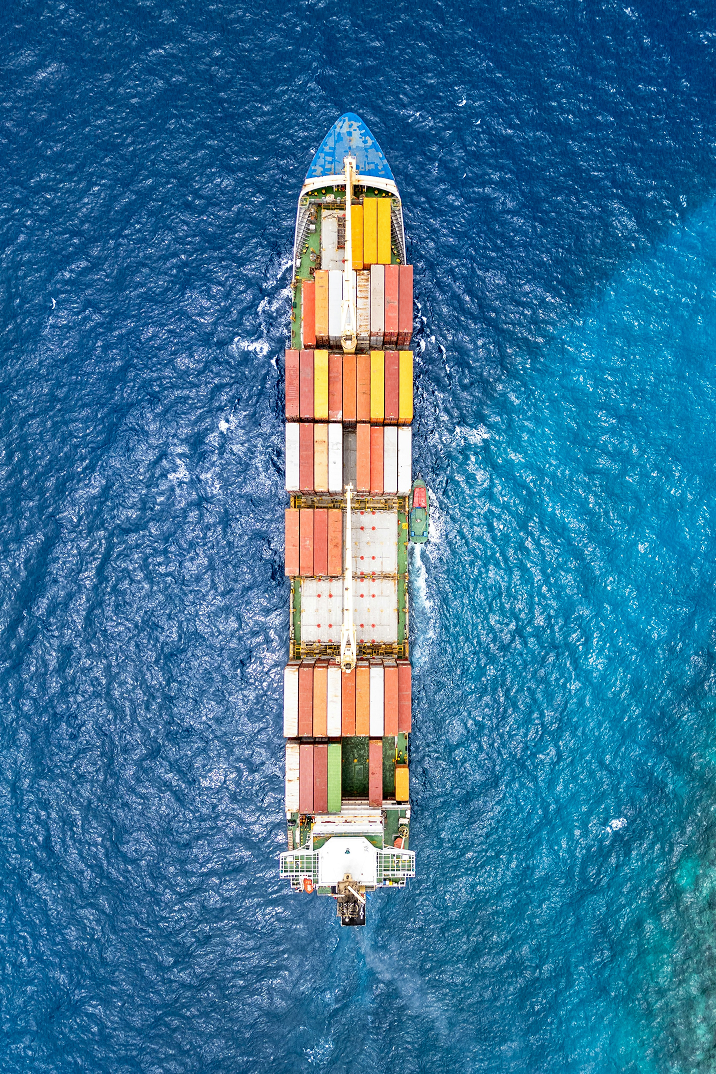 Fumée épaisse s'échappant d'une cheminée d'usine avec deux autres cheminées en arrière-plan au coucher du soleil.