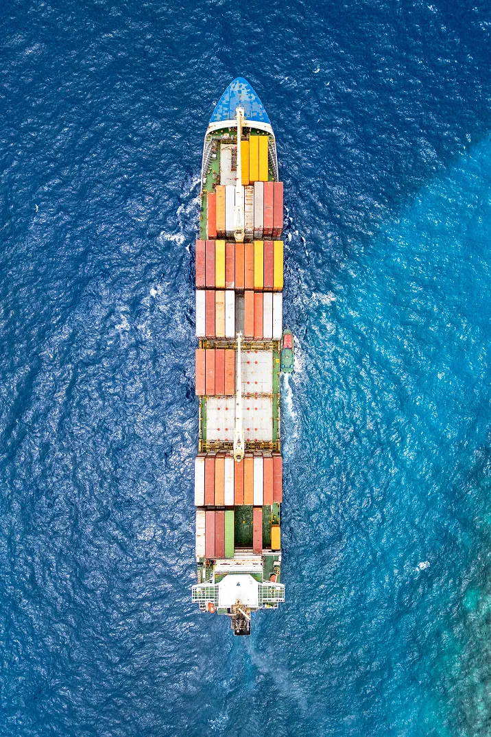 Fumée épaisse s'échappant d'une cheminée d'usine avec deux autres cheminées en arrière-plan au coucher du soleil.