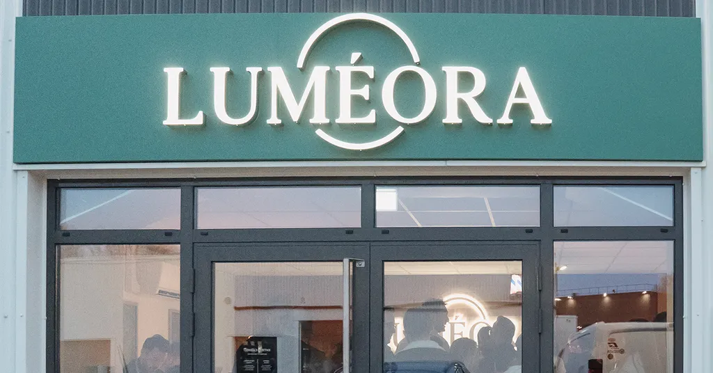 Entrée d'un centre  LUMÉORA avec une façade verte et une grande enseigne lumineuse au-dessus de la porte vitrée.
