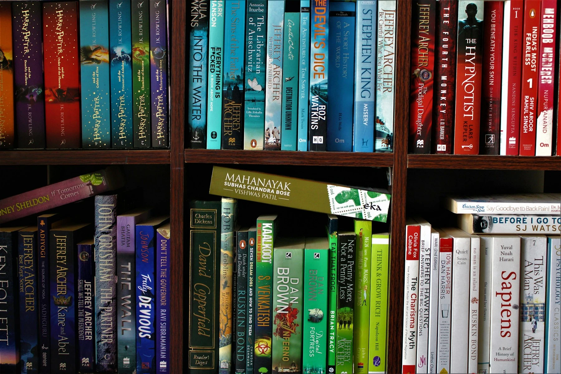 Close-up van een boekenkast vol boeken, zoals in een mini bieb