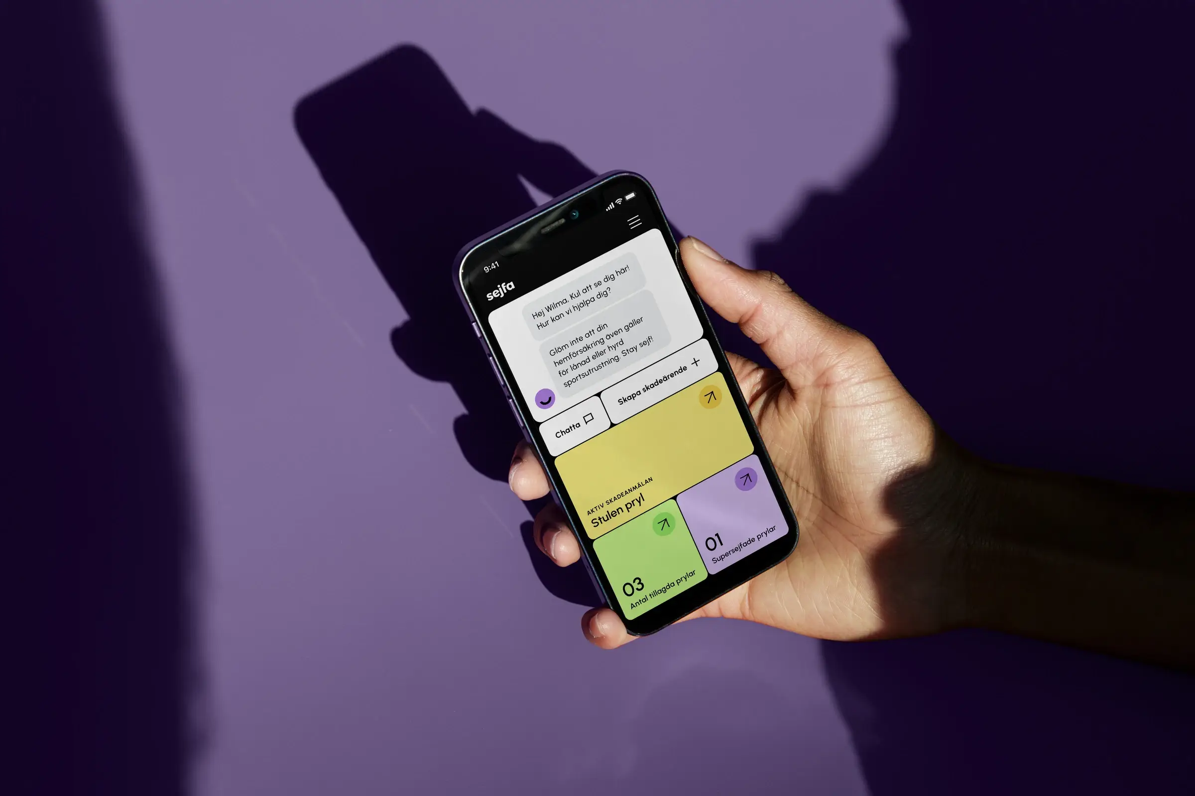 En hand som håller en smartphone som visar Sejfas app