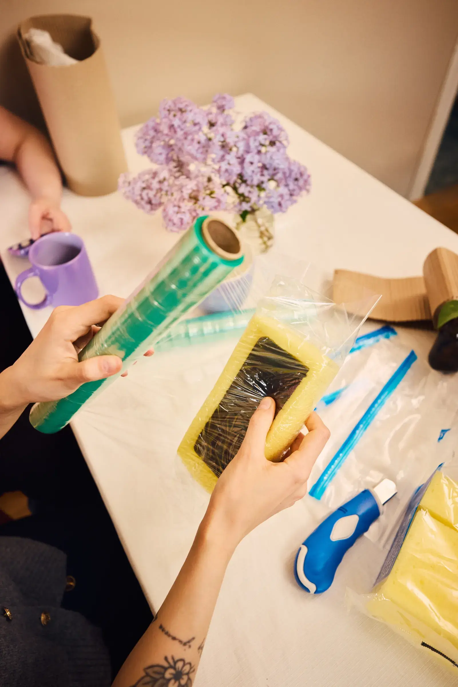 En mobiltelefon packas in med skyddande plast och frigolit – symbol för  trygghet och mobilförsäkring från Sejfa.