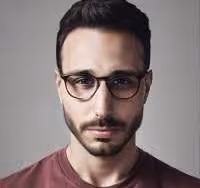 Portrait of a man with dark hair, glasses, and a short beard wearing a maroon shirt.