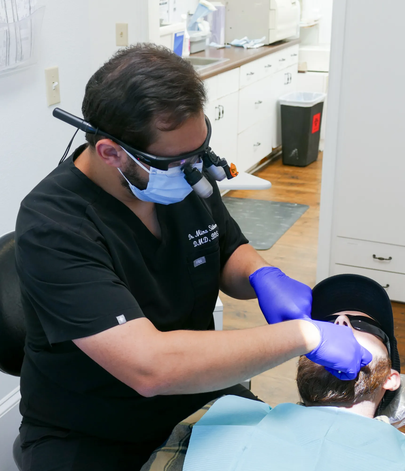 A waiting room with chairs, a small table, and a TV screen displaying an image.