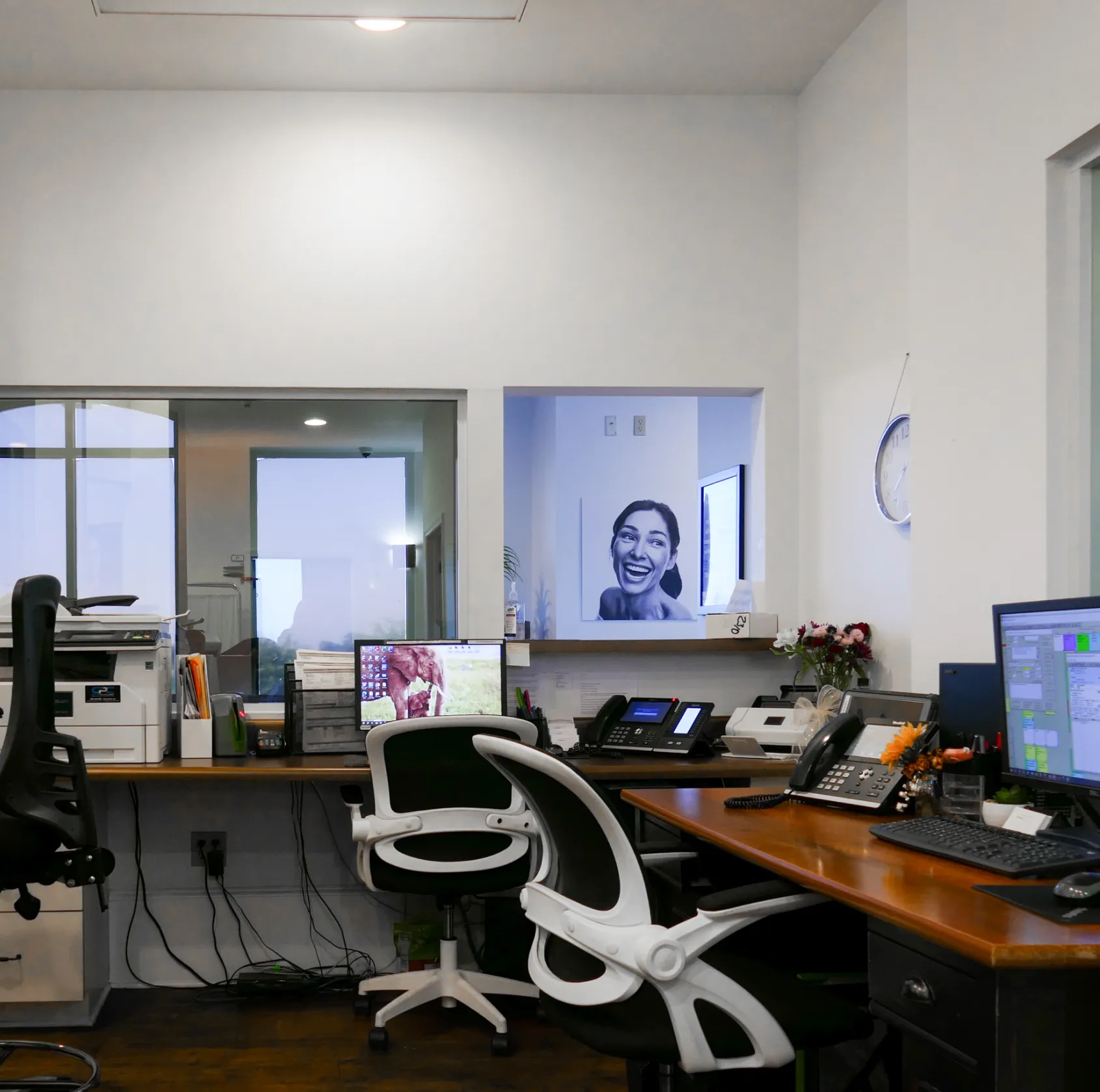 A hallway with a black-and-white photo on the wall and plants on a wooden table.