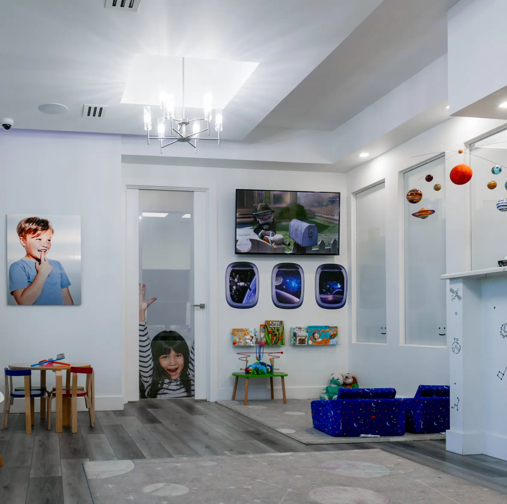 A children's playroom with colorful furniture and space-themed wall decorations.