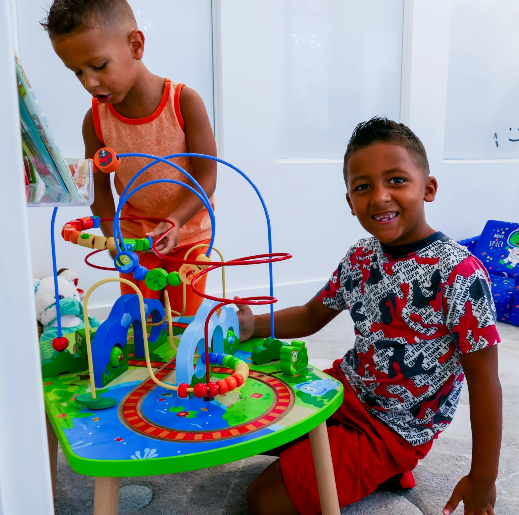 A woman in a white coat and flower clip makes a heart shape with her hands.