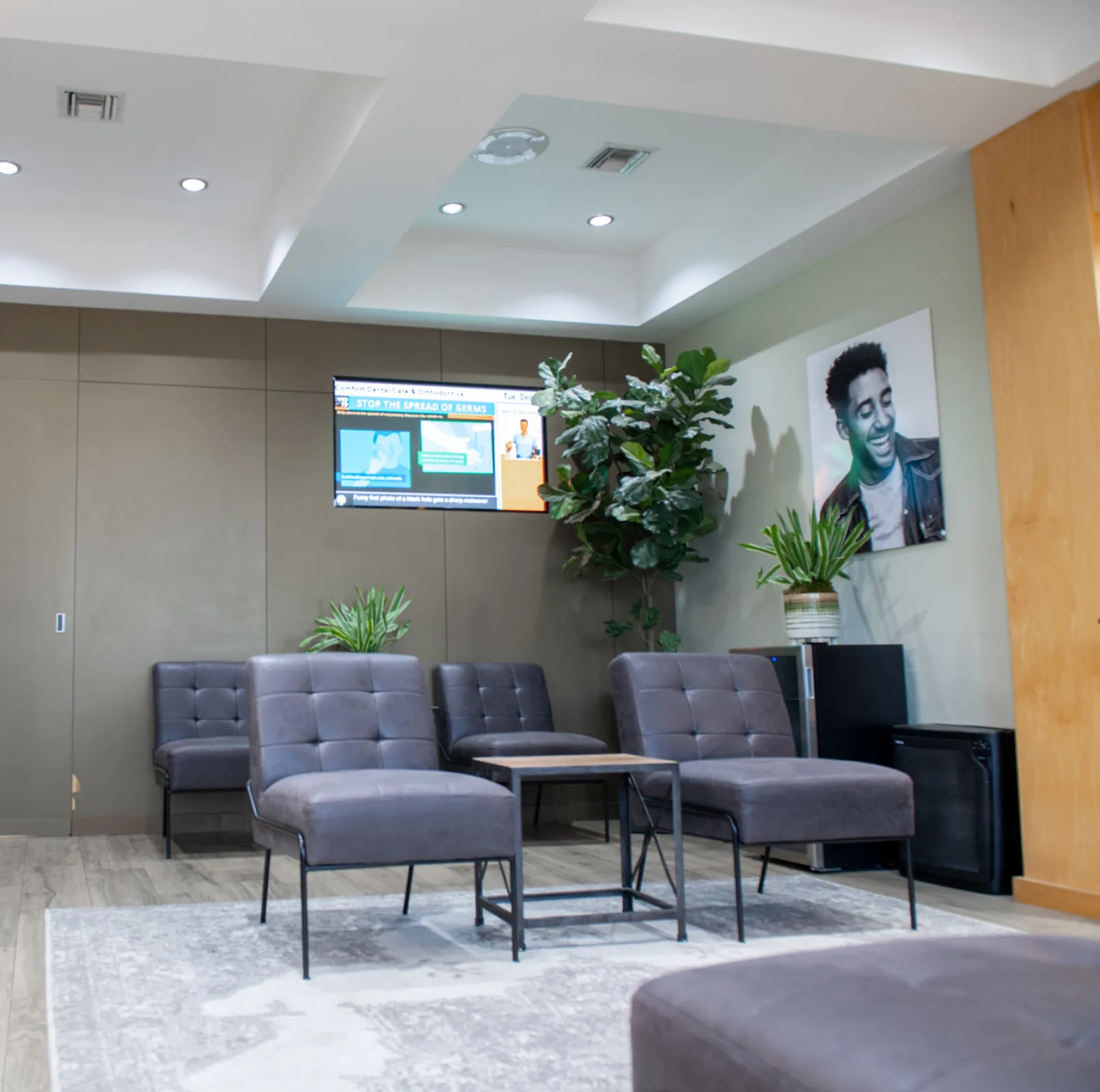 A dentist shows an older man his teeth in a hand mirror after a dental check-up.
