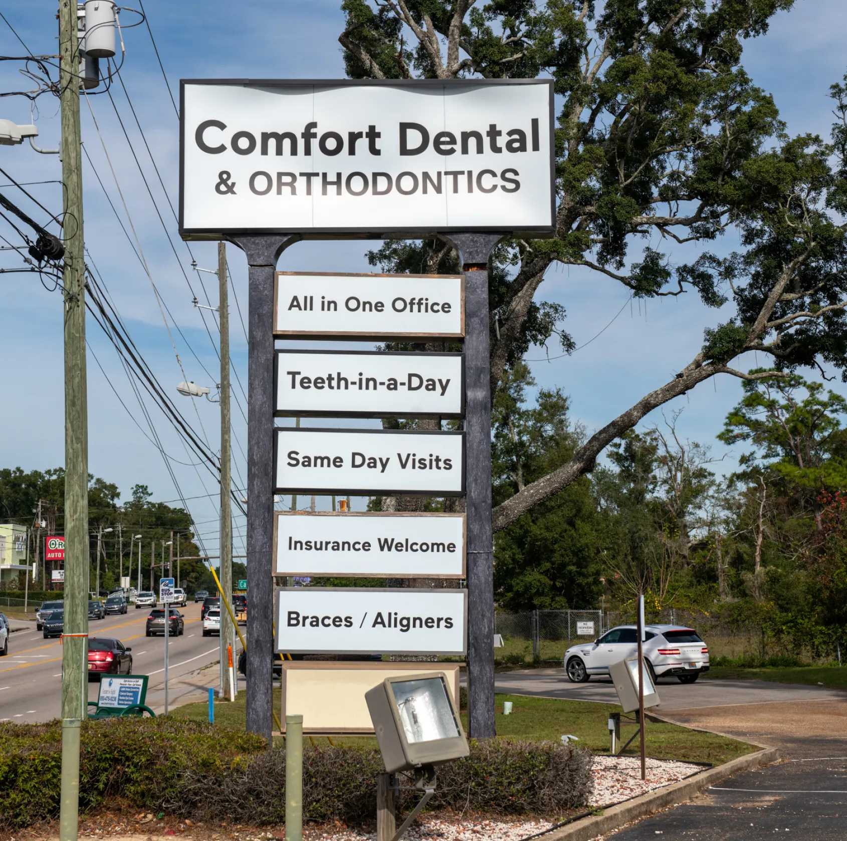 A dentist wearing a mask talks to a seated patient in a dental office.