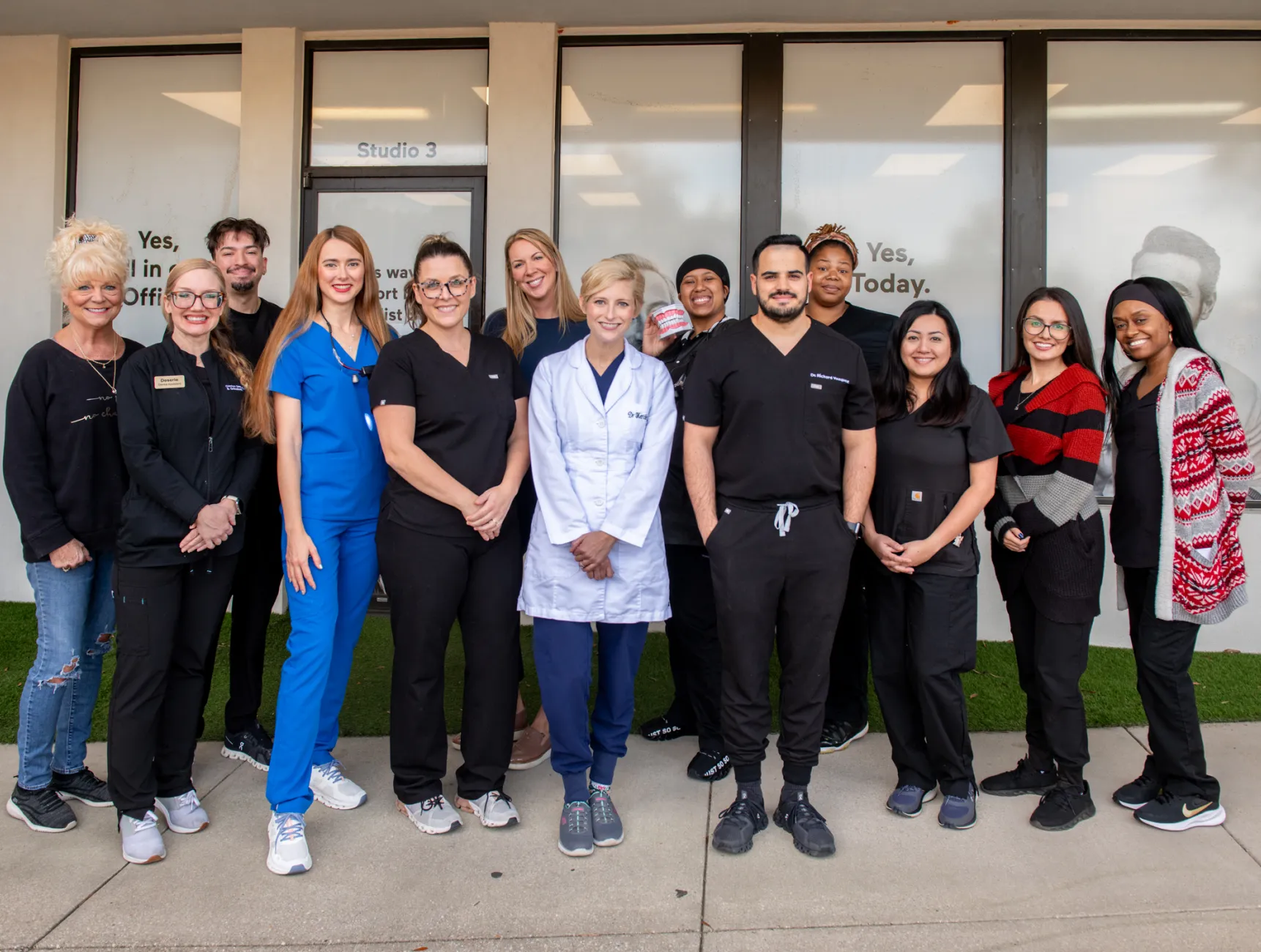 Two people dressed in black working on a computer at a reception desk.