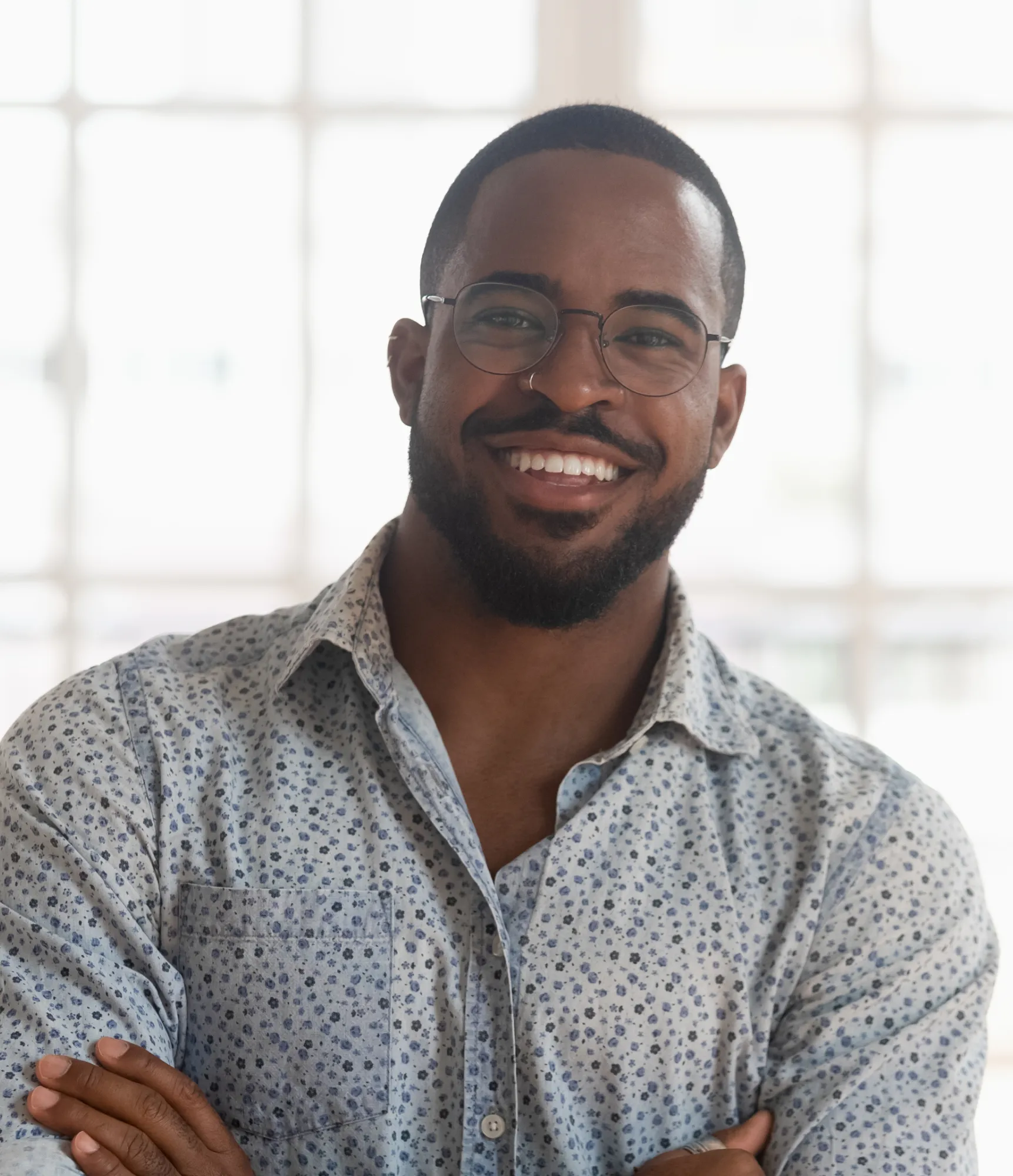A man is smiling while a dentist examines his teeth with dental tools.