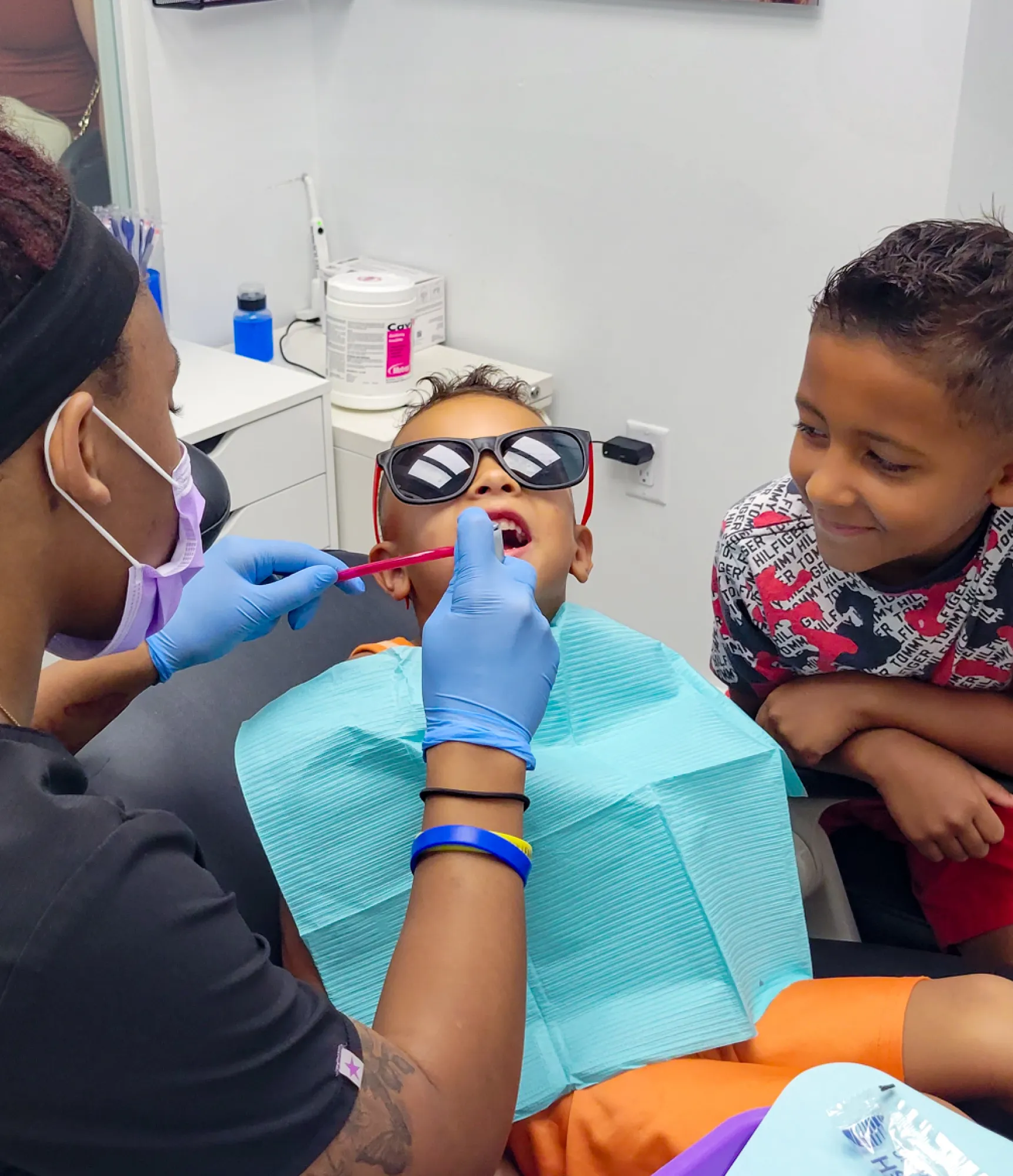 Two women at a desk, smiling, and looking at a computer screen. One is on the phone.