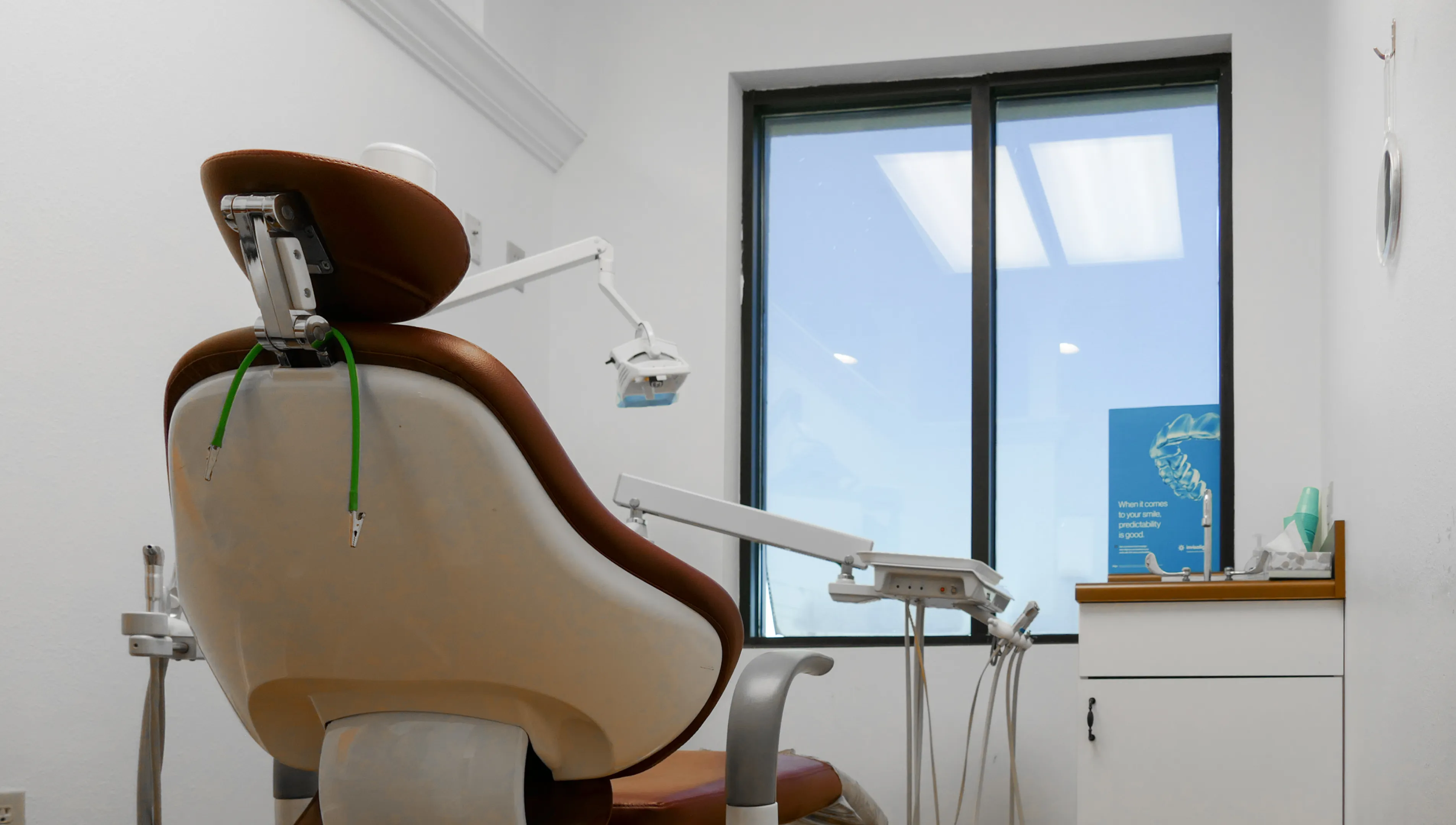 A waiting room with chairs, a wooden coffee table, and wall-mounted screens displaying images.