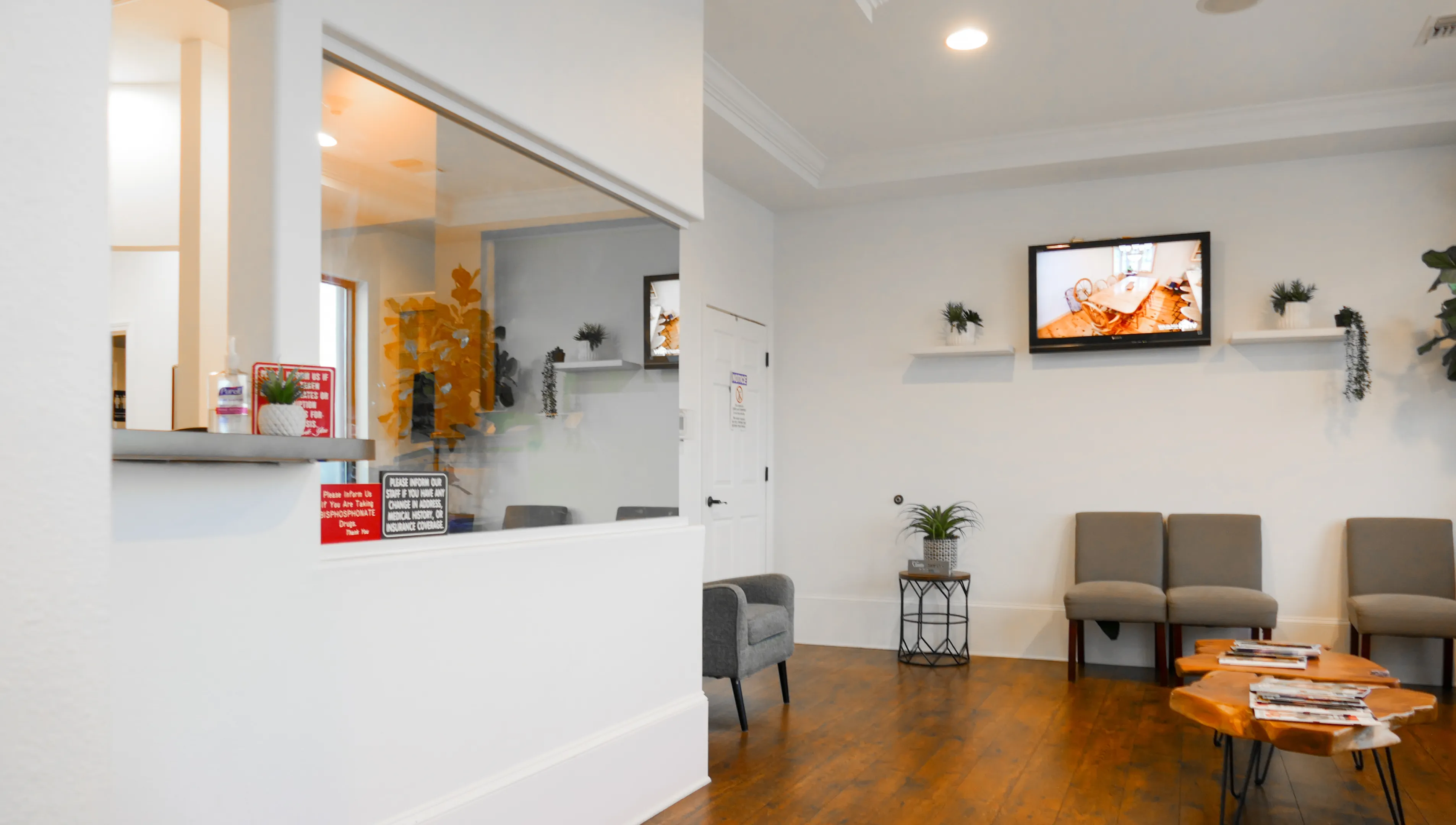 Bright waiting room with chairs, children's play area, and family photos on the walls.