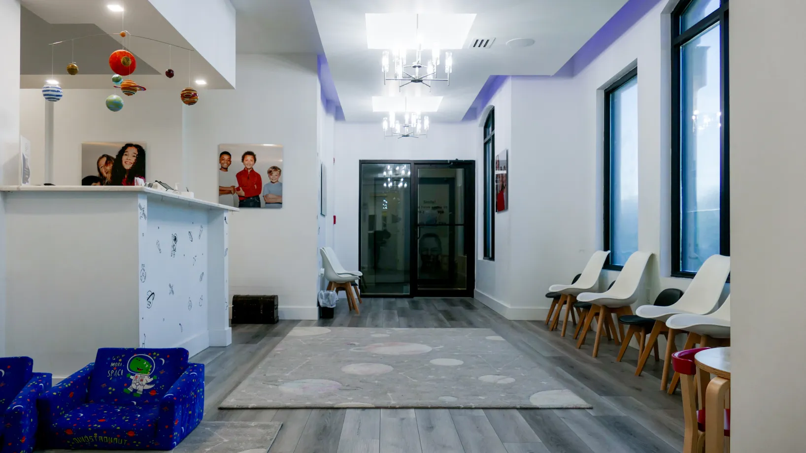 Child-friendly waiting room with colorful toys, playful wall art, and a small table with chairs.