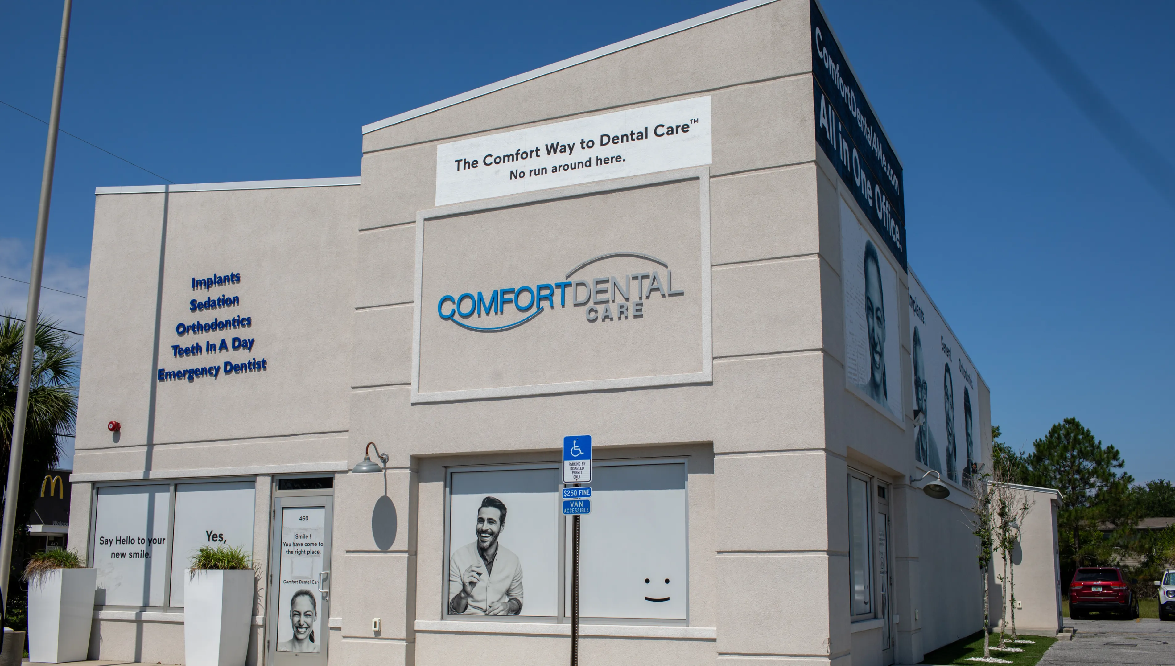A dental care clinic with signage promoting implants, orthodontics, and emergency services.