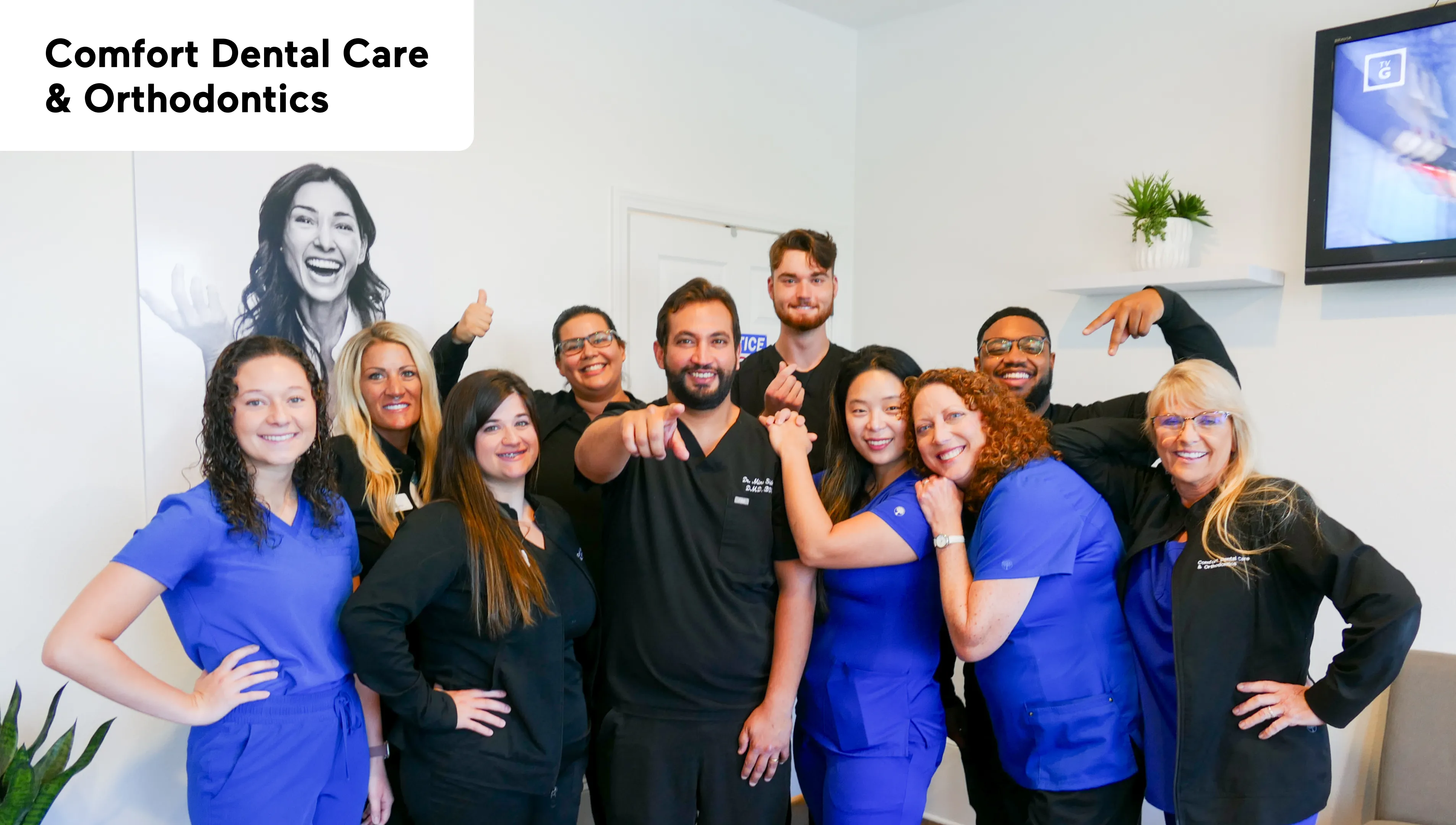 A wooden table with plants and a black-and-white portrait hangs on the wall above it.