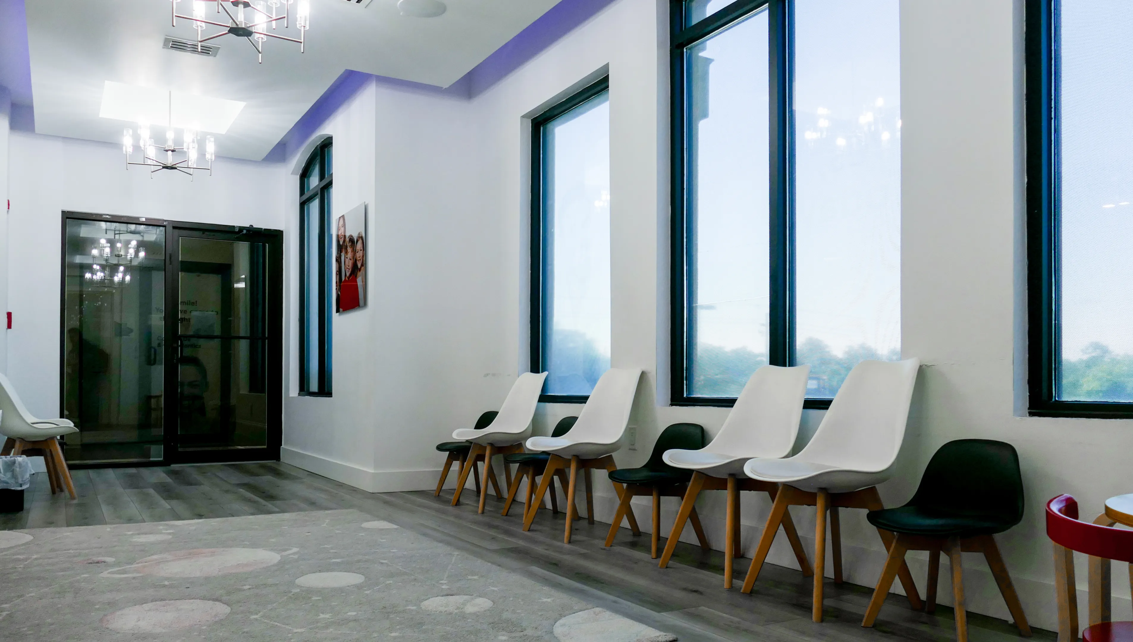 Two boys play with a colorful bead maze toy in a bright room.
