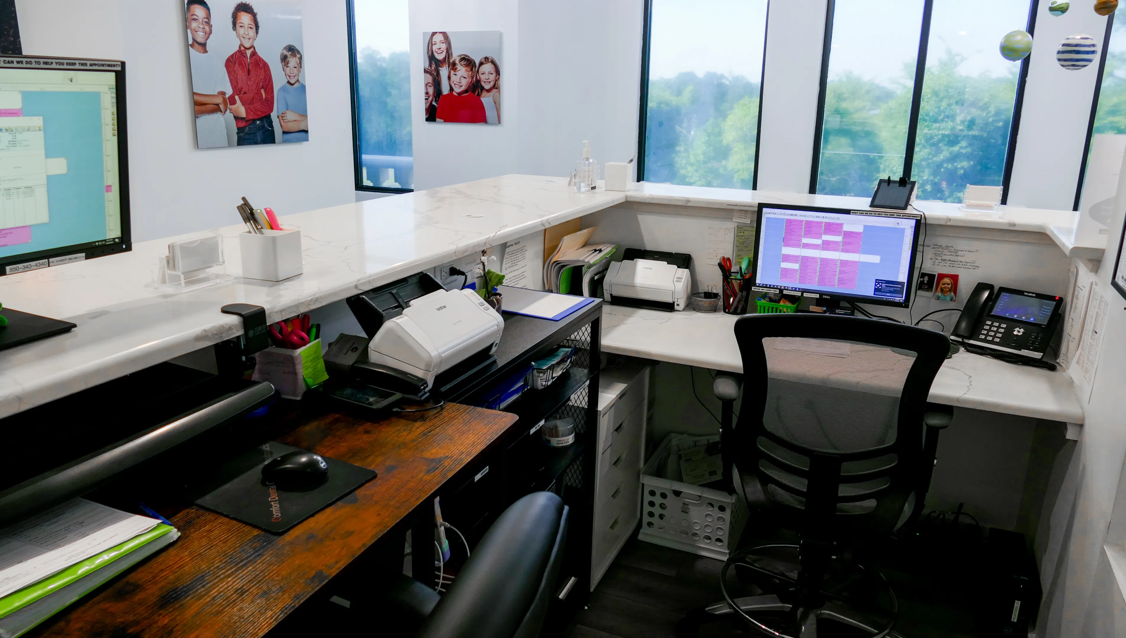 Two office chairs face computers on separate desks, with a printer and office items between them.